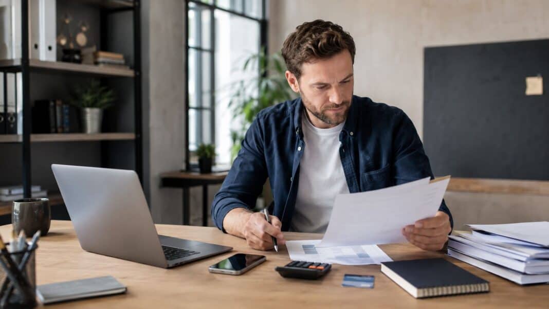 Geschäftskonto eröffnen: Die wichtigsten Fehler, die Gründer direkt am Anfang vermeiden sollten Gründer prüft Geschäftskonto und Unternehmensfinanzen am Laptop
